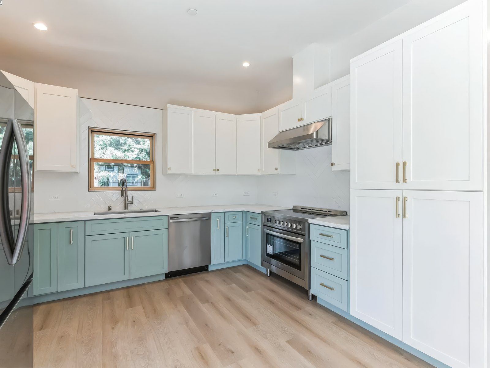 New-build ADU kitchen with blue shaker cabinets and white uppers in Carmichael