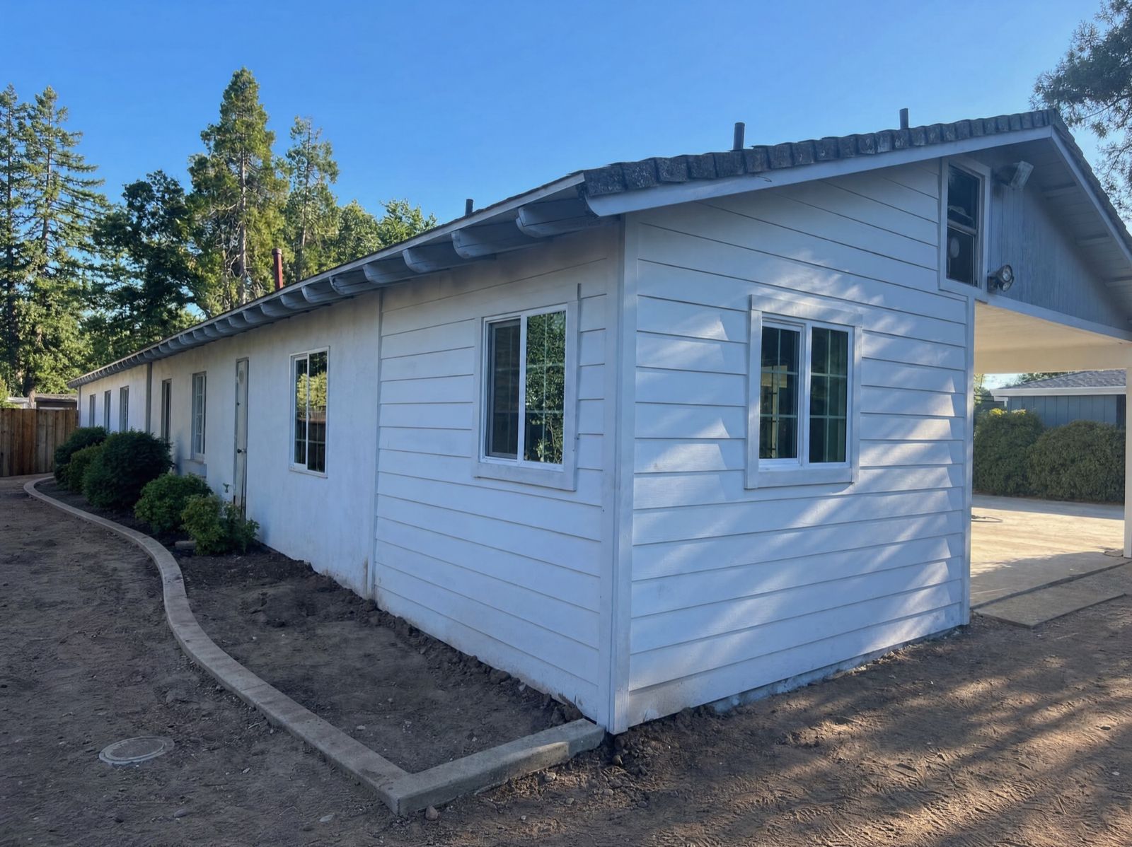 Finished backyard ADU with fresh white siding, built by Four Piers in Carmichael